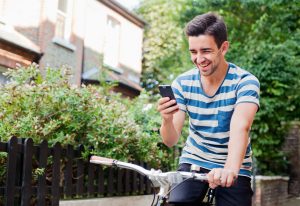 Young man using smart phone on bike